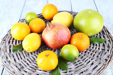 Ripe citrus on plate on wicker background