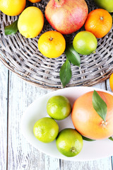 Ripe citrus on plate on wicker background