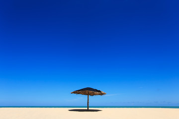 Wooden sun umbrella on the beach in Thailand