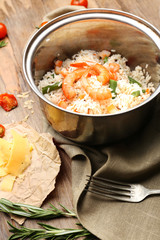 Tasty rice in pan on wooden table