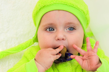 A little child holds a pacifier in his hand