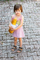 little girl holding a loaf of bread