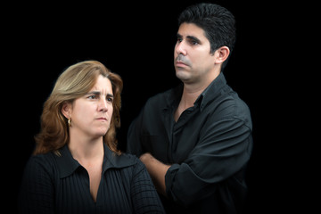 Angry and sad couple isolated on black