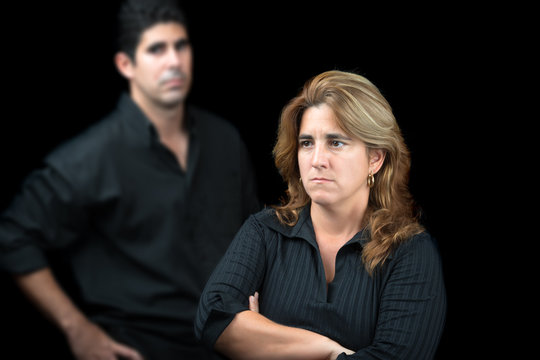Angry and sad couple isolated on black