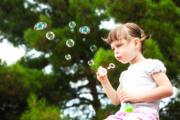 little girl blowing soap bubbles