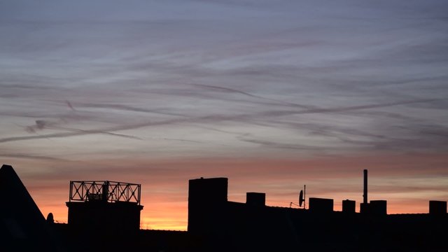 Sonnenuntergang &uuml;ber den D&auml;chern einer Stadt - Zeitraffer