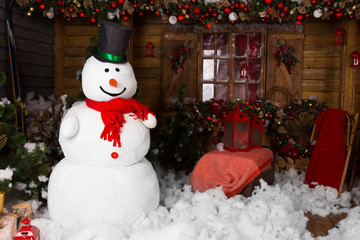 Large snowman on decorated wooden house