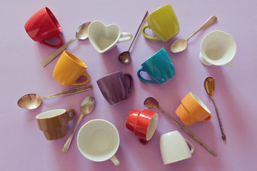 Background with colorful empty coffee cups and spoons