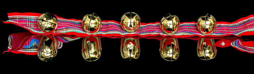 Golden Christmas bells on a colorful ribbon