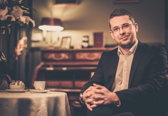 Middle-aged man behind table in luxury vintage style interior
