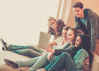 Group of young friends taking selfie in home interior