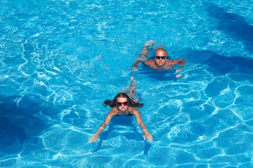 Obraz na płótnie Canvas Couple swimming in pool