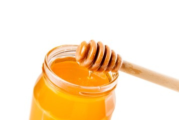 honey jar on white background with wooden honey dipper honey