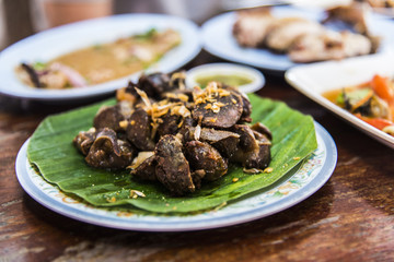 Chicken liver fried with garlic on banana leaf