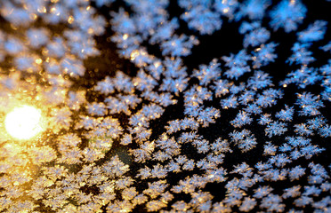 Hoarfrost (ice, snowflakes) on window glass at night