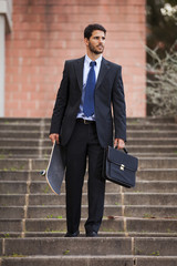 Businessman carrying his skateboard