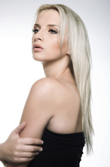 Obraz premium beautiful young woman with blonde hair posing on grey background
