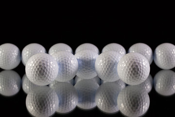 Golf balls on the black glass desk
