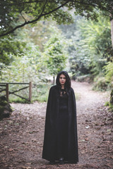 beautiful dark vampire woman with black mantle and hood