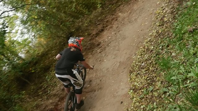 Young girl in helmet riding fast on her mountain bicycle slow