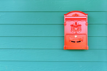Red mailbox with green wood background