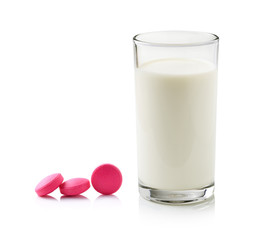 glass of milk and pill isolated on white background