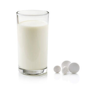 glass of milk and pill isolated on white background