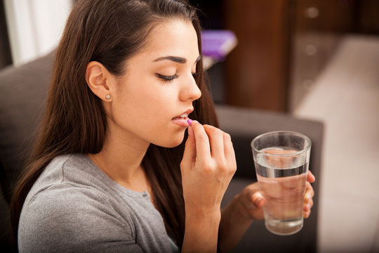 Young woman taking a pill