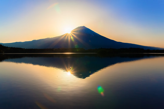 Sun shine and inverted Mount Fuji reflected in Lake Tanukiko
