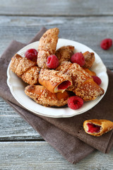 Croissants with raspberries on wooden boards