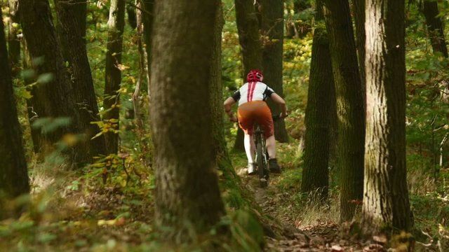 Young girl in helmet riding fast on her mountain bicycle slow