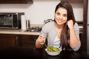 Obraz na płótnie Canvas Happy girl eating a salad
