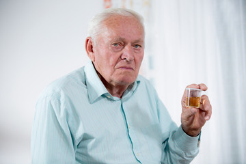 Senior male patient holding urin sample