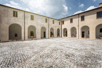 Empty cobblestone court surrounded by arcades