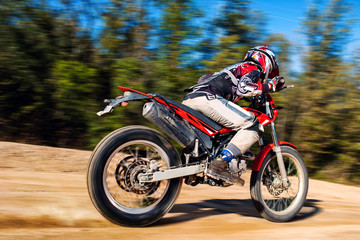 Fototapeta na wymiar Teen boy riding Motocross bike on gravel road