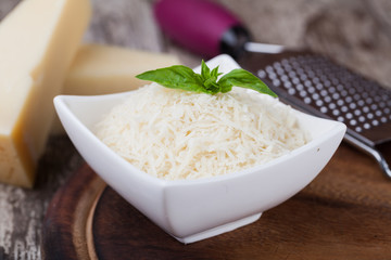 grated parmesan cheese and metal grater on wooden board