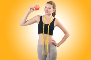 Woman with apple doing exercises on white