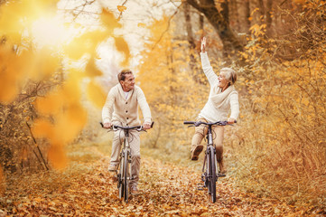 Active seniors ridding bike and having fun