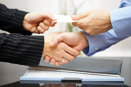 Business clients are exchanging business card  and handshakeing