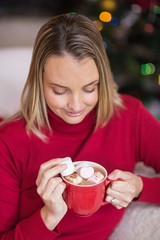 Happy blonde in winter clothes holding mug