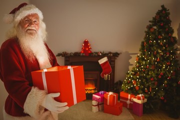 Obraz na płótnie Canvas Happy santa delivering presents at christmas eve
