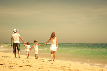 Happy  family  walking on the beach at the day time.
