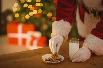 Santa picking cookie and glass of milk