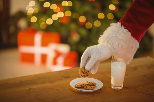 Hand of santa claus picking cookie