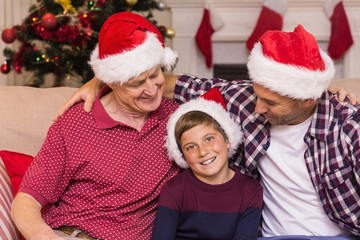 Fototapeta premium Portrait of grandfather father and son in santa hats