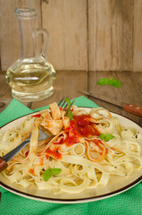 Pasta with tomato sauce on wooden table