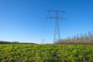 Transmission tower under a sunny sky at fall