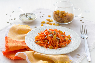 Carrot salad with raisins, sunflower seeds and honey. Copy space
