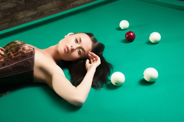 sexy girl in corset plays billiards.