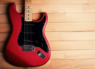 Fototapeta premium Red guitar on wooden background